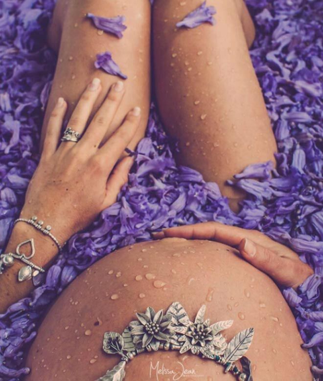 pregnant woman in bath of flower petals
